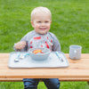 Cute blonde boy smiling and eating out of the gray Learning Bowl made from Silicone