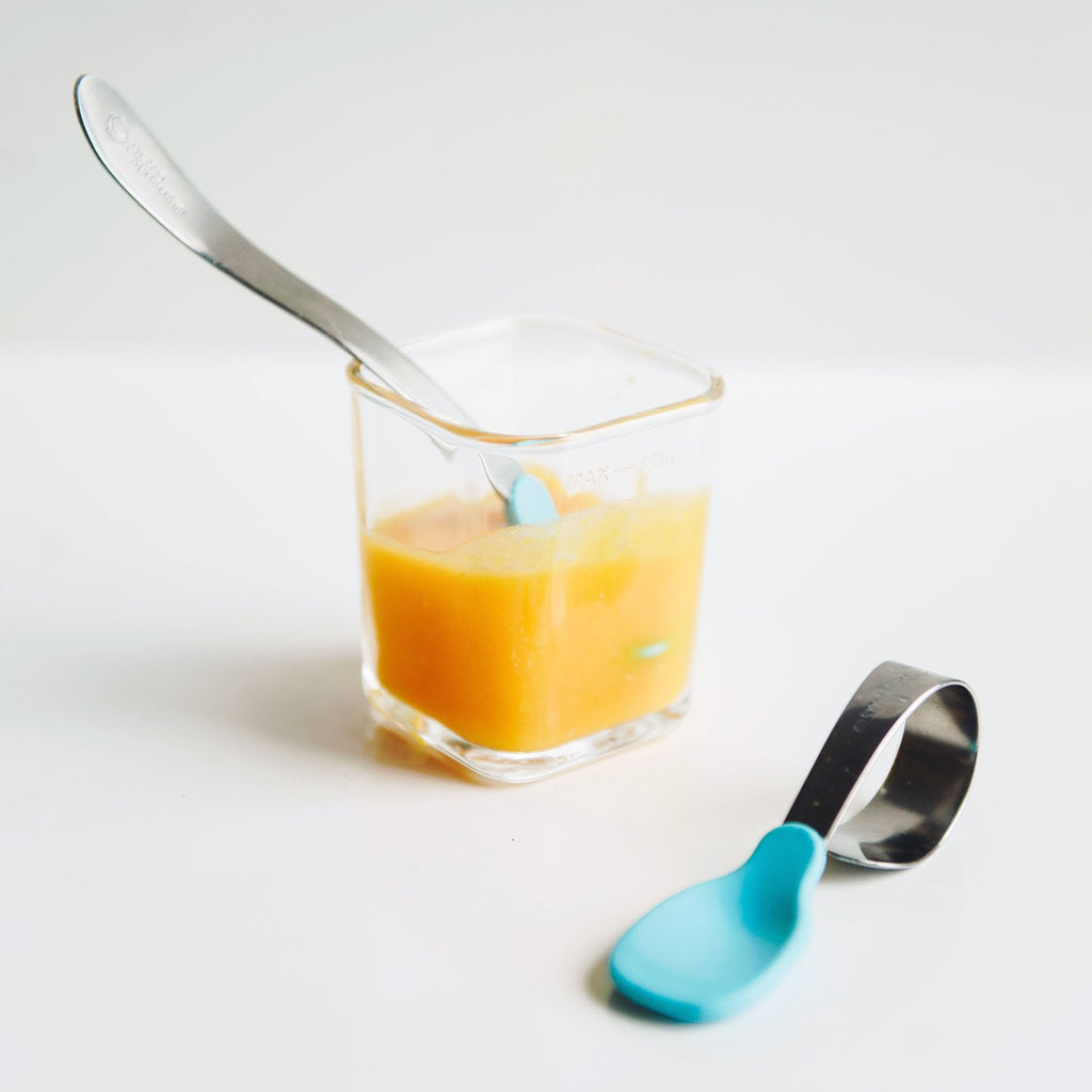An Aqua Learning Spoon by a glass food cube