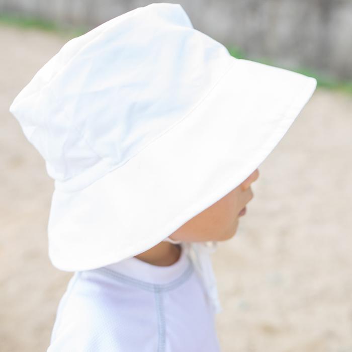 Looking at the back of a toddler's head with a white Bucket Sun Protection Hat on.